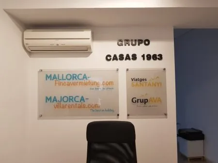 Rótulos de metacrilato en la pared de la recepción de una agencia de viajes