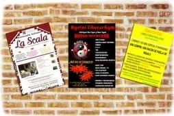 Carteles impresos pegados en un muro de ladrillo