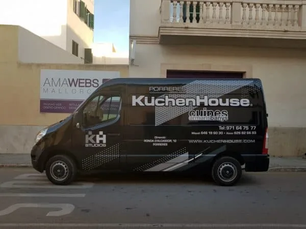 Furgoneta negra rotulada con el nombre de una empresa de cocinas