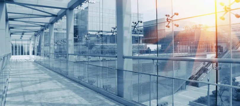 Pasarela acristalada de un edificio con láminas de control solar
